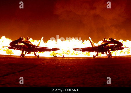 Due F/A-18 calabroni sedersi sulla linea di volo mentre una detonazione controllata di un muro di fuoco si spegne dietro di loro durante la notte parte del Marine Corps Air Station Air Show Ottobre 13, 2012 in California. Foto Stock