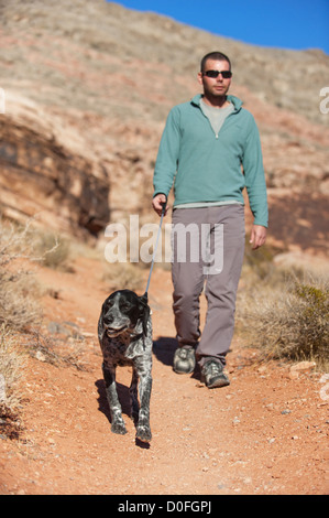 Un uomo passeggiate con il suo cane nella Red Rock Canyon, Nevada, STATI UNITI D'AMERICA Foto Stock