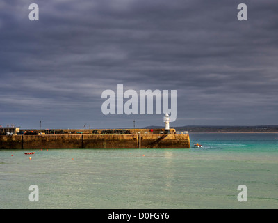 St Ives, Cornwall. Un pescatore che lascia il porto nel suo dinghy in un cupo novembre pomeriggio. Foto Stock