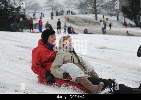 Amici in slittino Greenwich Park Londra Uk nel 2012 Foto Stock