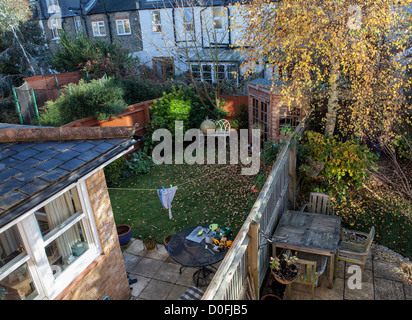 Autunno in suburbia - caduta foglie, scartato giocattoli e trampolino vuoto Foto Stock