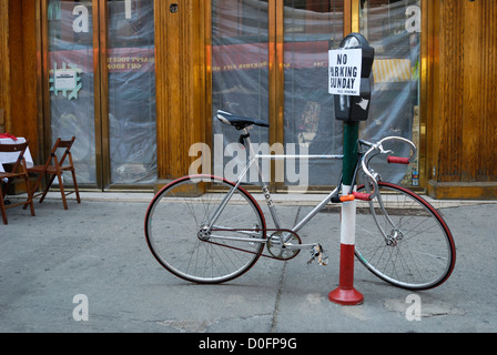 Una bici da corsa concatenati a un parchimetro con un parcheggio non oggi segno su di esso Foto Stock