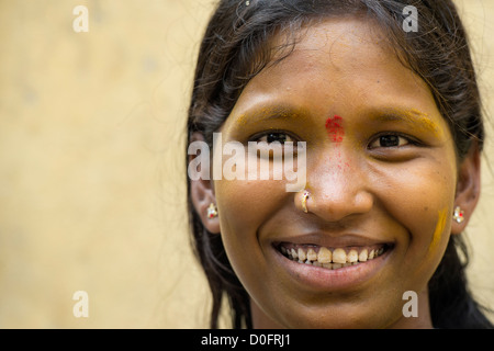 Sud giovane donna indiana con la curcuma coperto volto ritratto. Andhra Pradesh, India Foto Stock