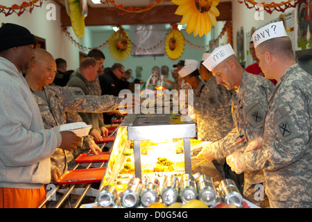 Unità comandanti, ufficiali e sergenti prima di servire un pasto di ringraziamento ai militari e civili a Camp Bondsteel in Kosovo. La sala da pranzo servizio fornito una cornucopia di cibo da prime rib e la Turchia, a torta alle noci pecan. Il facility manager ha preso effor extra Foto Stock