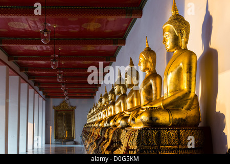 Fila di golden statue di Buddha a Wat Pho tempio di Bangkok, Tailandia Foto Stock