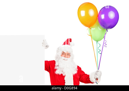 Un felice santa claus in piedi accanto ad uno sbozzato billboard e palloncini di contenimento isolato su bianco Foto Stock