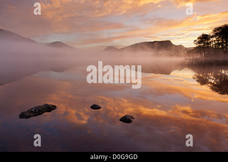 Pre alba colori riflessi sulla calma piatta superficie del Loch Awe a Argyll nelle Highlands, Scotland, Regno Unito Foto Stock