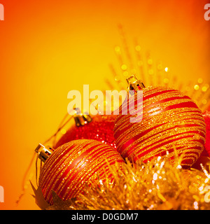 Immagine di rosso le bolle di Natale di confine, decorazioni di festa isolato su sfondo arancione, golden holiday ornamenti, Foto Stock