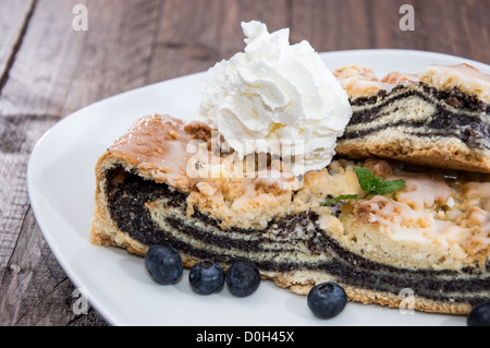 Piastra con fresca torta Poppy-Seed su sfondo di legno Foto Stock