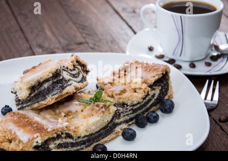 Piastra con fresca torta Poppy-Seed su sfondo di legno Foto Stock