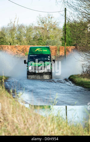 Billericay, Essex, Regno Unito. Ultimi heavy rain e saturo di acqua la massa ha portato ad un sacco di acqua di superficie in luoghi in Essex. Questo ha catturato alcuni piloti fuori in quanto colpiscono queste pozze a velocità che può condurre a motori allagata e arrivando a un arresto nell'acqua. Una città Link van fa scalpore attraverso l'acqua. Foto Stock