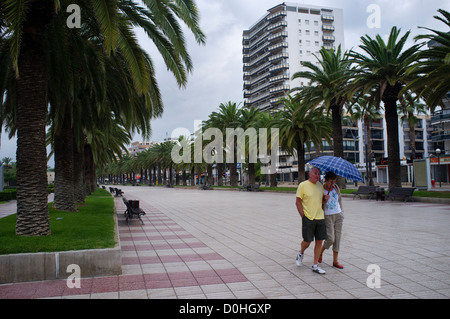 Due persone a piedi lungo la passeggiata nella cittadina turistica di Salou vicino a Barcellona. Foto Stock
