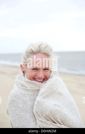 Felice, donna sorridente sulla spiaggia Foto Stock