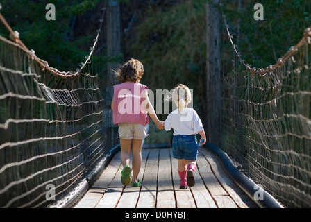 Due ragazze su un ponte di sospensione al di sopra dell'Oregon Fiume Umatilla. Foto Stock