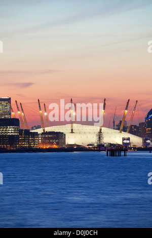 Una vista sul fiume Tamigi verso la città di Londra e la O2 Arena, Canary Wharf al tramonto. Foto Stock