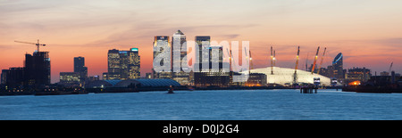 Una vista sul fiume Tamigi verso la città di Londra e la O2 Arena, Canary Wharf al tramonto. Foto Stock