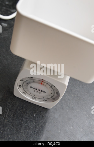 Bianco cucina salter bilancia sul tagliere Foto Stock
