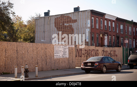 Pietre marroni, uno con una parete danneggiata dalla costruzione della porta accanto, sulla Lexington Avenue nel quartiere Bedford-Stuyvesant Foto Stock