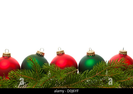 Fila di verde e rosso e ornamenti Natale con pino rami Foto Stock