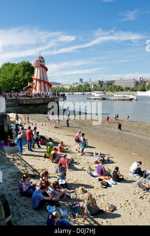 Gente che si diverte sul foreshore del fiume Tamigi. Foto Stock