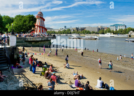 Gente che si diverte sul foreshore del fiume Tamigi. Foto Stock