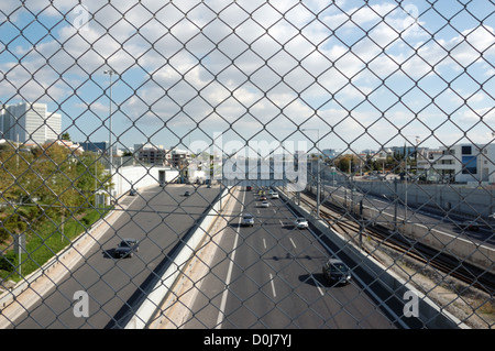 Auto in autostrada e la catena collegamento recinto. Il traffico della città. Foto Stock