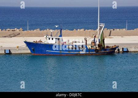 Peschereccio nel porto. Rusty dragger nave legata a riva. Foto Stock