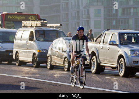 Ciclista e il traffico congestionato da Vauxhall Bridge di Londra. Foto Stock