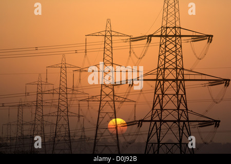 Elettricità tralicci profilarsi da un ambiente SUN. Foto Stock