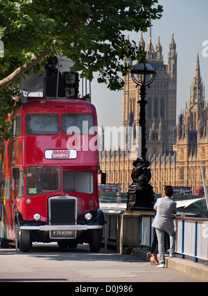 Un tradizionale London bus parcheggiato sul terrapieno di Waterloo con le case del Parlamento in background. Foto Stock