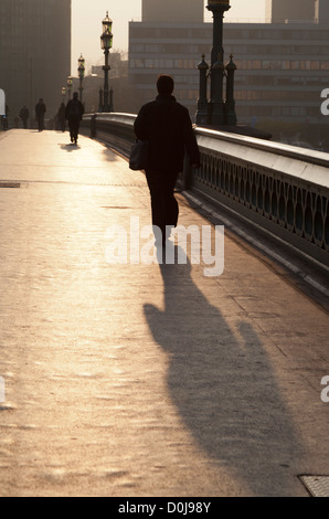 Un " commuter " sul Westminster Bridge a sunrise. Foto Stock