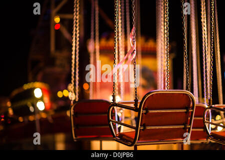Aberystwyth, Wales, Regno Unito. Il 26 novembre 2012. Esattamente 8 settimane dopo la sua scomparsa, un singolo nastro rosa è legato ad una sedia vuota su un fairground ride in memoria di mancanti 5 anno di età bambino aprile Jones. Aberystwyth novembre luna park. Foto Stock