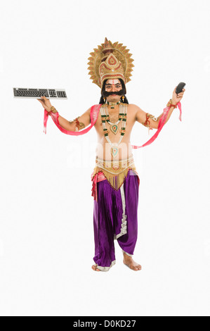 Uomo vestito come Ravana holding di apparecchiature informatiche Foto Stock