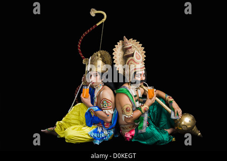 Due uomini vestiti come Rama e Ravana a bere il succo d'arancia Foto Stock