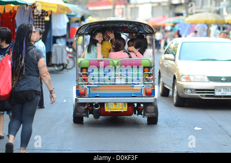 Una donna onde da un tuk-tuk a Bangkok, in Thailandia. Foto Stock