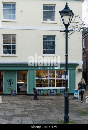 Totnes Devon England. Il 26 novembre 2012. Un deli delicatessen con la giovane lady passando in cut off shorts. Foto Stock