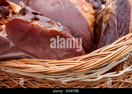 Prosciutto di maiale collocata in un cesto di vimini. Tradizionale cibo rumeno, deve precisare in particolare per il mese di dicembre. Foto Stock