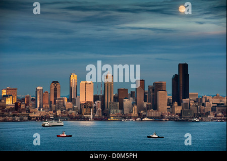 La luna piena sorge sopra la skyline di Seattle durante una chiara serata autunnale presi da Alki Beach in west Seattle. Foto Stock