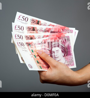 Donna di mano azienda cinquanta pound note REGNO UNITO valuta britannica Foto Stock