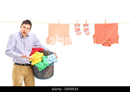 Angry man tenendo un cesto per la biancheria e una linea bucato con vestiti isolati su sfondo bianco Foto Stock