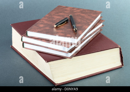 Spessore libro volume notebook e penna Foto Stock