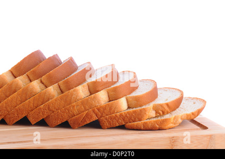 Primo piano della fa della pagnotta di pane bianco su un legno tagliere. Fette di pane vengono diffusi. Foto Stock