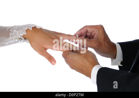 Primo piano dello sposo il posizionamento di un anello di nozze in spose in mano. Formato orizzontale su uno sfondo bianco. Foto Stock