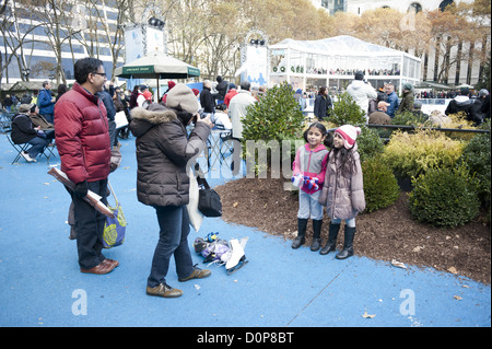 Madre ispanica di scattare foto delle sue figlie vicino al laghetto di Citi al Bryant Park di Manhattan il fine settimana del Giorno del Ringraziamento, nov. 24, 2012. Foto Stock