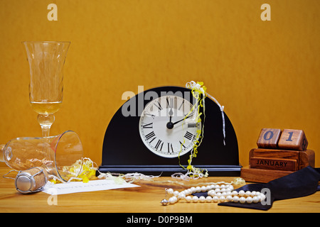 Nuovi anni di vita ancora la foto di un orologio che mostra subito dopo la mezzanotte con champagne, sughero, un bow tie, collana di perle Foto Stock