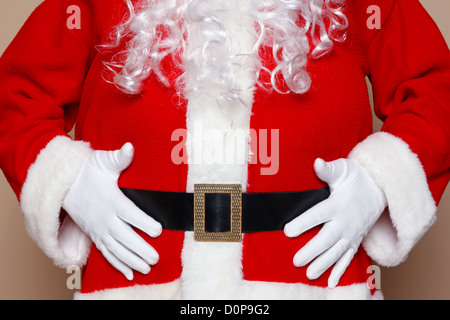 Santa Claus tenendo il suo ventre, due molti cookie credo. Foto Stock