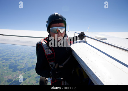 Man over 55 anni si prepara per un skydive il salto. In tal modo egli detiene a bordo dell aeromobile e dando il conteggio di uscita. Foto Stock