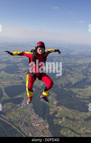 Questo paracadutista si diverte e la caduta libera in una posizione di sedersi con 120mph velocità su terra di Nizza scape. Foto Stock