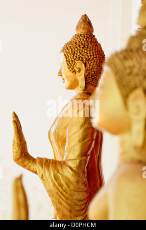 VIENTIANE, Laos - Golden statue del Buddha in un Wat (Tempio buddista) in Vientiane, Laos. Questa statua è in stile cambogiano. La messa a fuoco è sulla statua in background con profondità di campo ridotta. Foto Stock