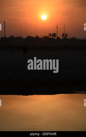 VIENTIANE, Laos - la regolazione del sole sopra il fiume Mekong in Vientiane, Laos. Poiché il fiume segna il confine, gli alberi e le torri che si stagliano sulla riva opposta del fiume sono in Thailandia. Con copyspace. Foto Stock